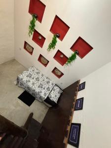 a living room with a bed and some plants on the wall at Casa e Chalé raio de sol in Caraíva +1 photo