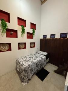 a room with a bed and a wall with pictures at Casa e Chalé raio de sol in Caraíva