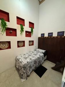 a room with a bed and a wall with pictures at Casa e Chalé raio de sol in Caraíva