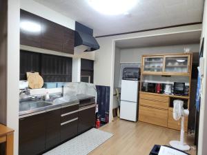 a kitchen with a sink and a refrigerator at ゲストハウス若水黒崎 in Kitakyushu