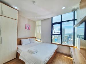 a bedroom with a bed and a large window at Gold Ocean Apartment Nha Trang in Nha Trang
