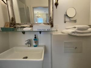 a bathroom with a sink and a mirror and towels at Hotel Söruper Hof in Sörup +38 photos