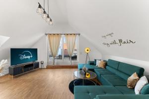 a living room with a blue couch and a tv at flair Alte Brauerei I Altstadt I Parkplatz I Kaffee I Highspeed WLAN I Xbox I Disney plus in Kitzingen