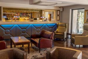a bar with leather chairs and a bar at The Ashbourne Hotel, BW Signature Collection in North Killingholme