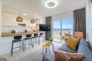 a living room with a couch and a kitchen at Playa La Arena 2 Bed Apartment in Puerto de Santiago +23 photos
