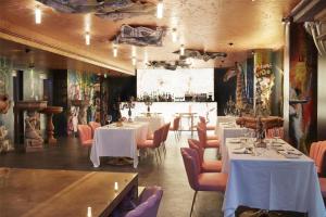 a dining room with white tables and pink chairs at Collini Rooms, WorldHotels Crafted in Milan