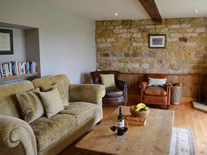 a living room with a couch and a table at Mullins Cottage in Gristhorpe
