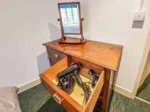 einen Holztisch mit einem Spiegel darüber in der Unterkunft Riverside Cottage in Lynton
