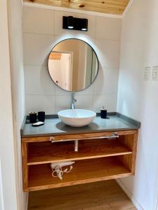 Un baño con un lavabo y un espejo sobre un mostrador. en Henko 2, en Villa La Angostura