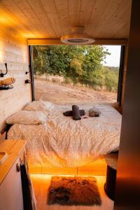 PinayにあるLodge Grand Confort - 1h de Lyon - Vue sur Loireの大きな窓が備わる小さな部屋のベッド1台分です。