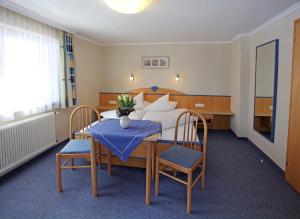 a room with a bed and a table and chairs at Haus Helga in Kappl
