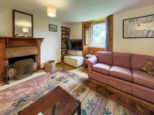 a living room with a couch and a fireplace at Croftfoot in Arnisdale