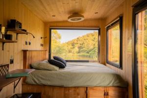 a bed in a tiny house with a large window at Lodge Grand Confort - Salle de bain italienne - Au coeur du Vignoble à 10 min de la Mer in La Londe-les-Maures