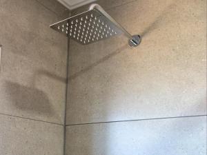 un soffione doccia sul pavimento in bagno di Wild Olive Luxury Accommodation a Hutton Heights Altre 28 foto