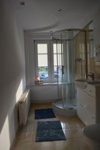 a bathroom with a shower and a tub and a sink at Apartament Margarita in Mrągowo