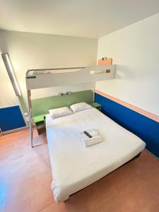 a bed in a room with two bunk beds at ibis budget Belfort Centre in Belfort