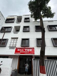 SipraにあるHillview Residencyの前に木がある背の高い白い建物