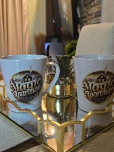 two coffee mugs sitting on top of a glass table at Magic Apartman Kop - Kraljevi Cardaci in Kopaonik