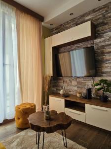 a living room with a tv on a brick wall at Magic Apartman Kop - Kraljevi Cardaci in Kopaonik