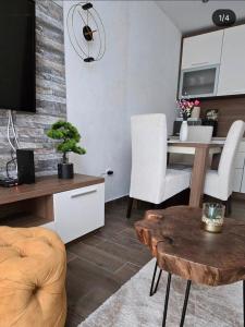 a living room with a table and white chairs at Magic Apartman Kop - Kraljevi Cardaci in Kopaonik