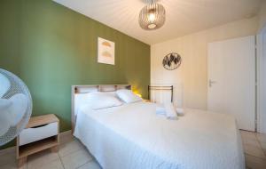 a bedroom with a white bed and a green wall at L'évasion viticole Clim- cour fermée & parking privé au pied de la roche de Solutré in Solutré-Pouilly