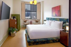 a bedroom with a large white bed and a table at The Barnett, part of JdV by Hyatt in New Orleans