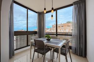 a dining room with a table and chairs and large windows at Verodal 2 Bedroom Apartment in Los Cristianos +6 photos
