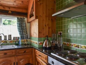 a kitchen with wooden cabinets and a stove top oven at Skyber - Uk50374 in Camelford