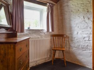 a wooden chair in a room with a window at Skyber - Uk50374 in Camelford