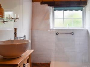a bathroom with a bowl sink and a window at Skyber - Uk50374 in Camelford +3 photos