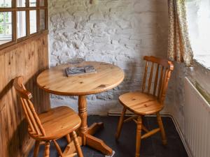 a wooden table and two chairs in a room at Skyber - Uk50374 in Camelford