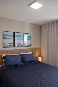 a bedroom with a bed with four pictures on the wall at Quarto e sala irretocável Beach Class Ondina in Salvador +40 photos