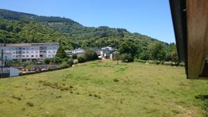 a grassy hill with houses and buildings in the background at Casa Poy in Becerreá