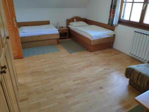 a room with two beds and a wooden floor at Antela - large apartment 142m2 for 12 persons in Pohorje