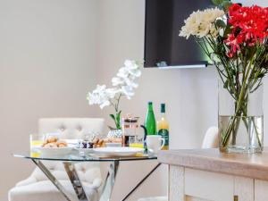 a dining room table with a vase of flowers on it at Twoo Hoots in Holt