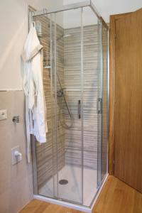 a shower with a glass door in a bathroom at Nido Alpino - Nel cuore delle Dolomiti in Pieve di Cadore +13 photos