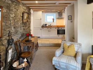 a living room with a couch and a table and a kitchen at Lock Heather Cottage in Reeth
