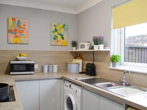 a kitchen with a sink and a microwave at Harbour View in Tayport