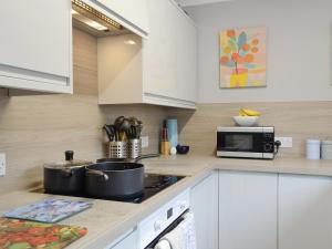 a kitchen with a stove and a microwave at Harbour View in Tayport