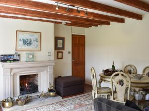 a living room with a fireplace and a table at Glebe Farm Cottage in Hornby