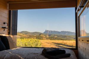 a bedroom with a large window with a view of a field at Prairie de la Gervanne - Panorama Drôme & Vercors in Beaufort-sur-Gervanne