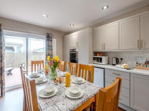 a kitchen with a dining table with chairs and a tableablish at Cherry Blossom - Uk48837 in Skegness