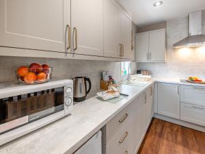 a kitchen with white cabinets and a bowl of fruit on the counter at Cherry Blossom - Uk48837 in Skegness +13 photos