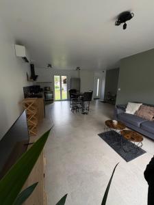 a living room with a couch and a table at Gîte 3 Ptits Chats in Saint-Aubin