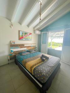 a bedroom with a bed in a room with a window at Villa Zandoli in Le Diamant +19 photos