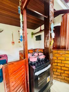 une cuisine avec une cuisinière avec des casseroles et des poêles roses dans l'établissement Aconchego da praia, à Arraial do Cabo