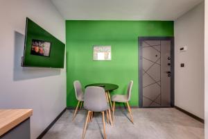 a dining room with green walls and a table and chairs at La Shara Building in Sofia