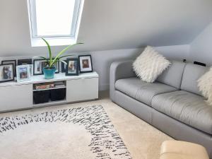 een woonkamer met een bank en een raam bij The Loft - Uk50517 in Falmouth