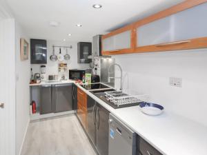 een keuken met een spoelbak en een aanrechtblad bij The Loft - Uk50517 in Falmouth