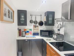 een keuken met een spoelbak en een magnetron bij The Loft - Uk50517 in Falmouth +7 foto's
